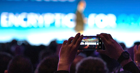 Event attendee taking a photo of the stage with their smartphone
